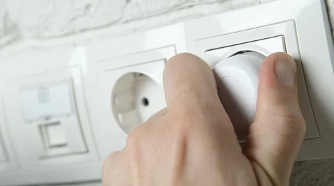 Closeup of a man's hand inserting an electrical plug into a wall socket. Stock Footage 58216458