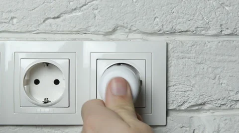 Closeup of a man's hand inserting an electrical plug into a wall socket. Stock Footage 58216569