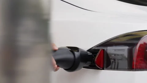 Closeup of man's hand inserts the charging cable to charge electric eco car Video stock 332235678