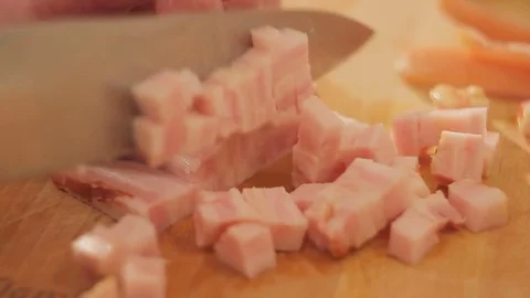 Closeup of a man's hand with a knife on a cutting board cuts bacon Stock Footage 81158963