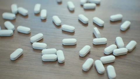 Closeup man's hand take one pill. White pills on the table. Stock Footage 88556963