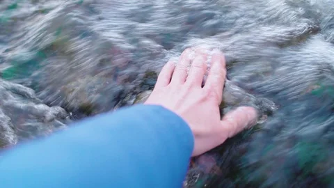 Closeup of mans hand touching river stream 库存影片 106450958