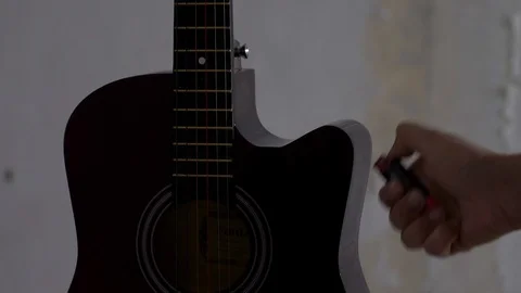 Closeup of a man's hand using lighter to set fire on a guitar. Stock Footage 100432943