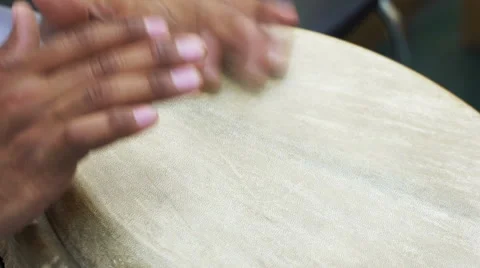 Closeup man's hands drumming out beat on skin-covered bongo hand drum. SLOW MO  Stock Footage 68992978