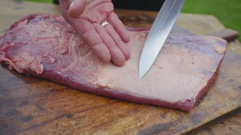 Closeup of man's hands elegantly presenting raw beef brisket on wooden Vídeos de archivo 137333208