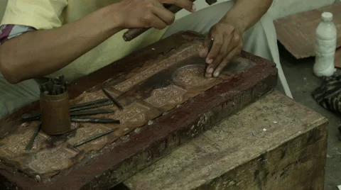 A closeup of a man's hands hammering a piece copper metal artwork Stock Footage 48034008