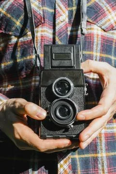 Closeup of man's hands holding vintage two-lens film camera, selective focus Stock Photos