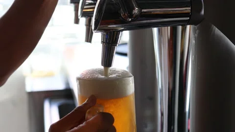 Closeup of man's hands pouring a cold mug of beer on a tap in a bar Stock Footage 221488926