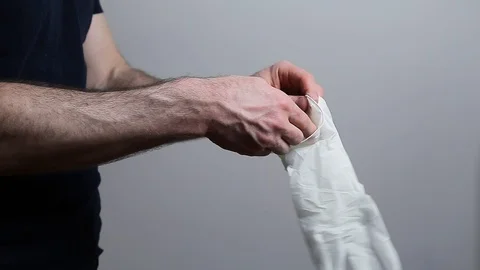 A closeup of a mans hands putting on latex gloves. 24FPS HD. Stock Footage 128498528
