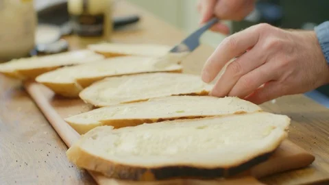 Closeup Of Man's Hands Spreading Butter On Slices Of Bread Stock Footage 86070385