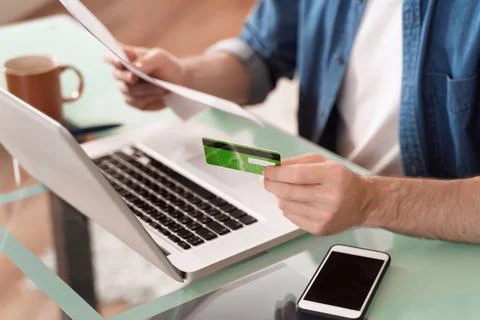 Closeup of man's hands using credit card and laptop for e-commerce Stock Photos