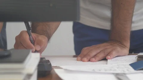 Closeup of a man's hands working on a desk writing over a paper project Stock Footage