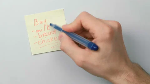 Closeup man's hands write on yellow sticker paper sheets word beer instead Stock Footage 87807374