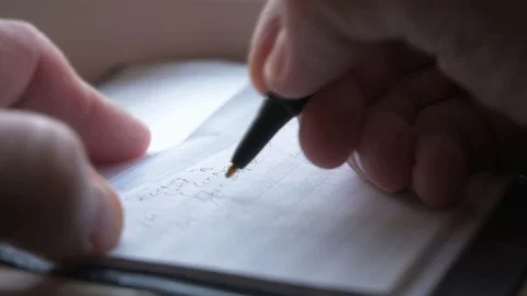 Closeup of a man's hands writing in a personal checkbook ledger. Stock Footage 128518975
