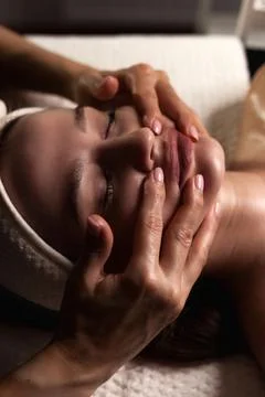 Closeup of masseur hands does relaxing facial massage for beauty lady in medi Stock-Fotos