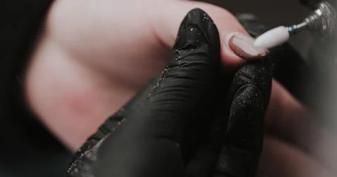 Closeup of master in black gloves making manicure using electric equipment Video stock 149365635