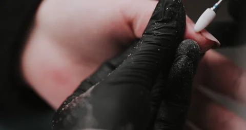 Closeup of master in black gloves making manicure using electric equipment Video stock 149365698