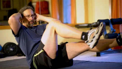 Closeup of a mature man doing bicycle balance crunches for ab exercises. Stock Footage 99051802