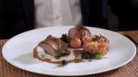 Closeup of meat dish plate in fine dining restaurant. Man is eating the dish Stock Footage 89045816