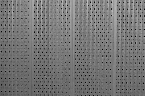 Closeup of a metal plate that has a pattern of holes 스톡 사진