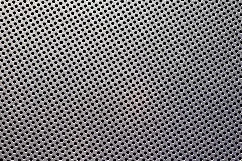 Closeup of a metallic surface with tiny holes for textures and overlays Foto stock