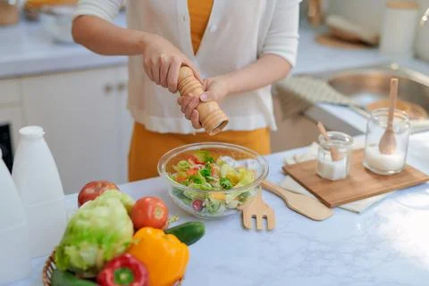 Closeup mid section of a chef putting salt and Pepper in the kitchen Stock Photos