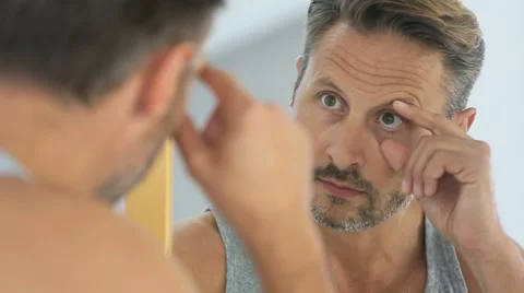 Closeup of middle-aged man insterting contact lens Stock Footage 56065859