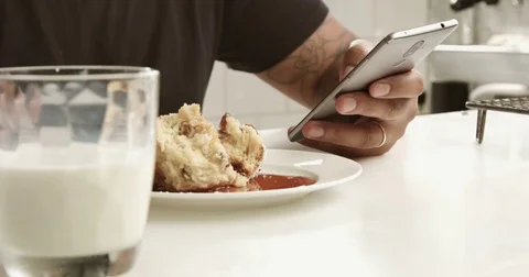 Closeup of mixed race man's hand texting in smartphone during breakfast Stock Footage 78507698