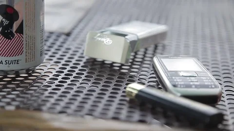 Closeup of a mobile phone and a pack of cigarettes lying on the table in a cafe Video stock 71915792