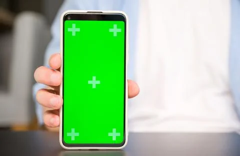 Closeup Mockup image of a man holding and showingsmartphone with green chroma Stock Photos