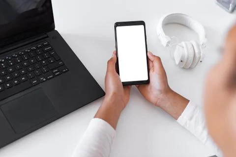 Closeup mockup image of white empty blank smartphone in the female hand Stock Photos