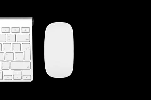 Closeup of a modern computer keyboard and mouse isolated on black background. Stock Photos