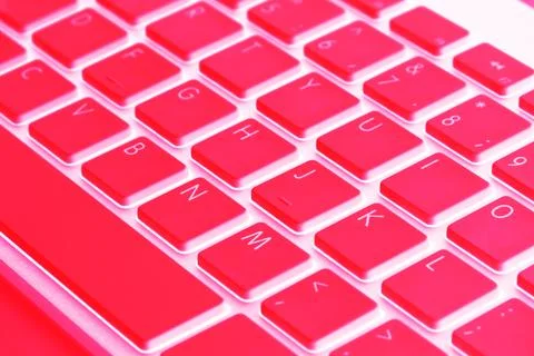 Closeup of a modern computer keyboard keys in red tones. Close up view of a.. Stock Photos