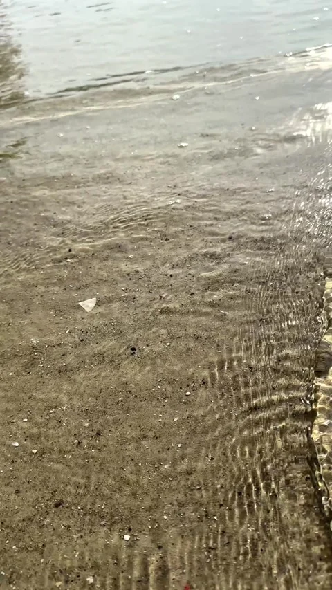Closeup moving shot of sea waves at the beach with sunlight Stock Footage 324557384