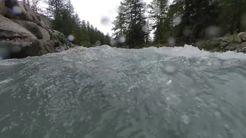 Closeup moving view of an alpine stream on a rainy summer day with a bridge Stock Footage 137394634