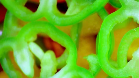 Closeup. Multi colored slices of bell pepper on a rotating background. top view Stock-Footage 128465189