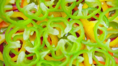 Closeup. Multi colored slices of bell pepper on a rotating background. top view. Video stock 129721291