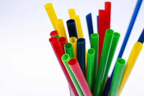 Closeup Of Multicolored drinking straws in a yellow cup over white studio b.. Stock Photos