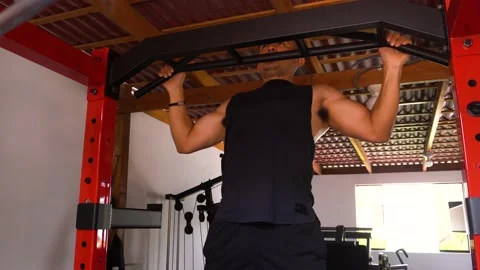 Closeup of muscular man doing pull-up exercises in his personal home gym Stock Footage 146505735