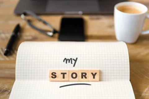 Closeup on notebook over wood table, focus on wooden blocks with letters Stock Photos