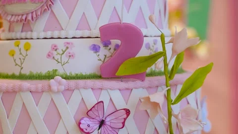 Closeup of number 2 candle on pink birthday cake Stock Footage 265446474