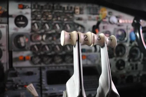 Closeup of Numbered Airplane Control Levers Against Blurred Cockpit Panel Stock Photos