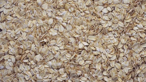 Closeup oat flakes falling into bowl Stock Footage 97936334