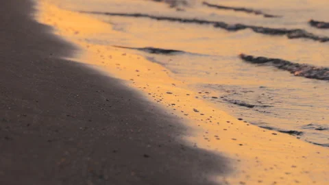 Closeup of Ocean Waves and Sand in Golden Light at Sunrise at the Beach Stock Footage 242301016