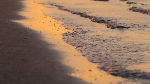 Closeup of Ocean Waves and Sand in Golden Light at Sunrise at the Beach Stock Footage 242301257