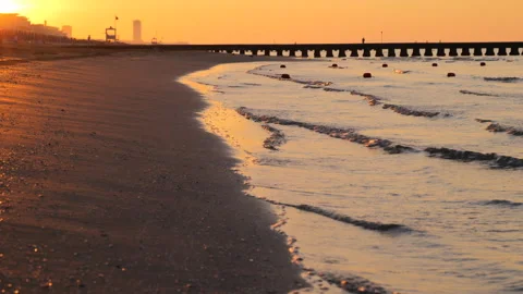Closeup of Ocean Waves and Sand in Golden Light at Sunrise at the Beach Stock Footage 242301422