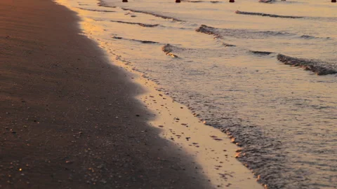 Closeup of Ocean Waves and Sand in Golden Morning Light at Sunrise at the Beach Video stock 242301596