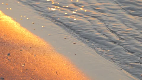 Closeup of Ocean Waves and Sand in Golden Morning Light at Sunrise at the Beach Stock Footage 242301816
