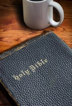 Closeup of Old Bible on Table With Coffee Mug Background Foto stock