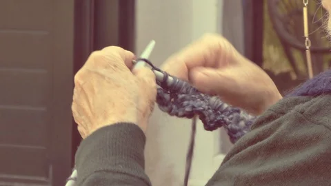 Closeup on old lady hands to knitting in a terrace Stock Footage 128689039
